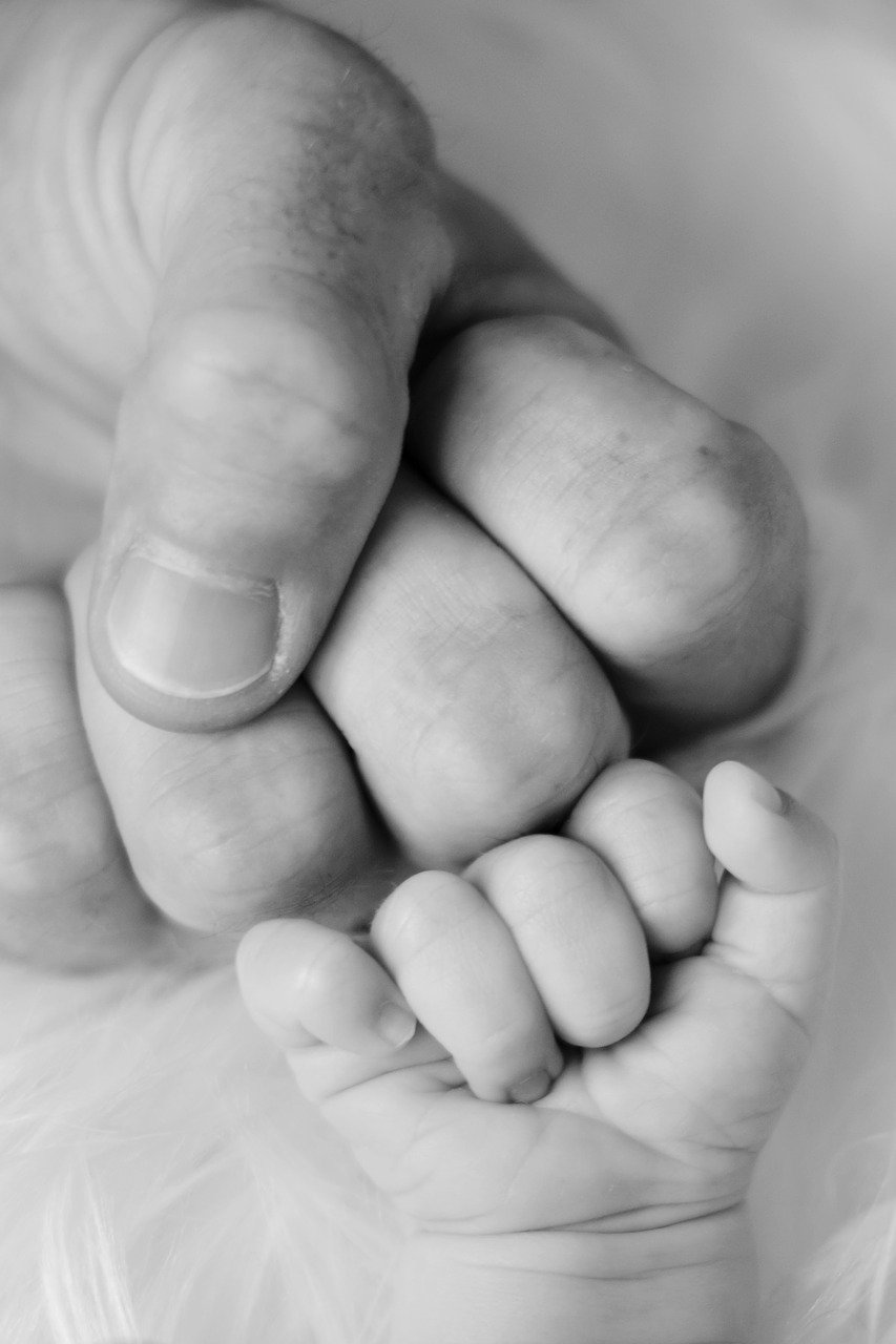 father and baby fist pumping black and white